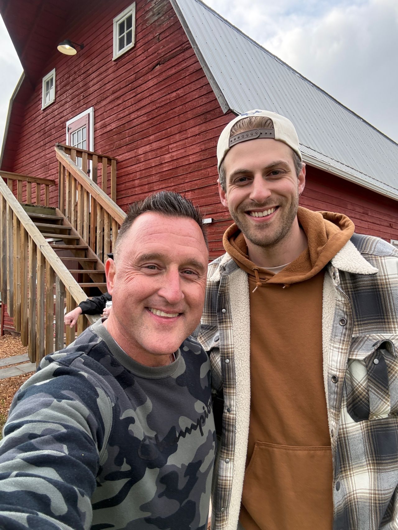 Two members outside the red barn
